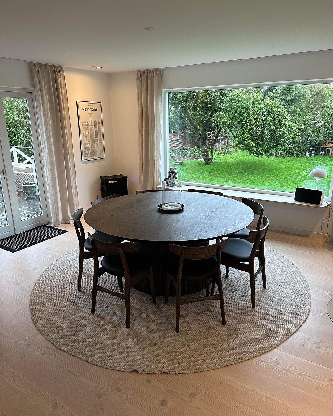 Round extendable solid wood dining table with wood pipe legs in dark oak.
