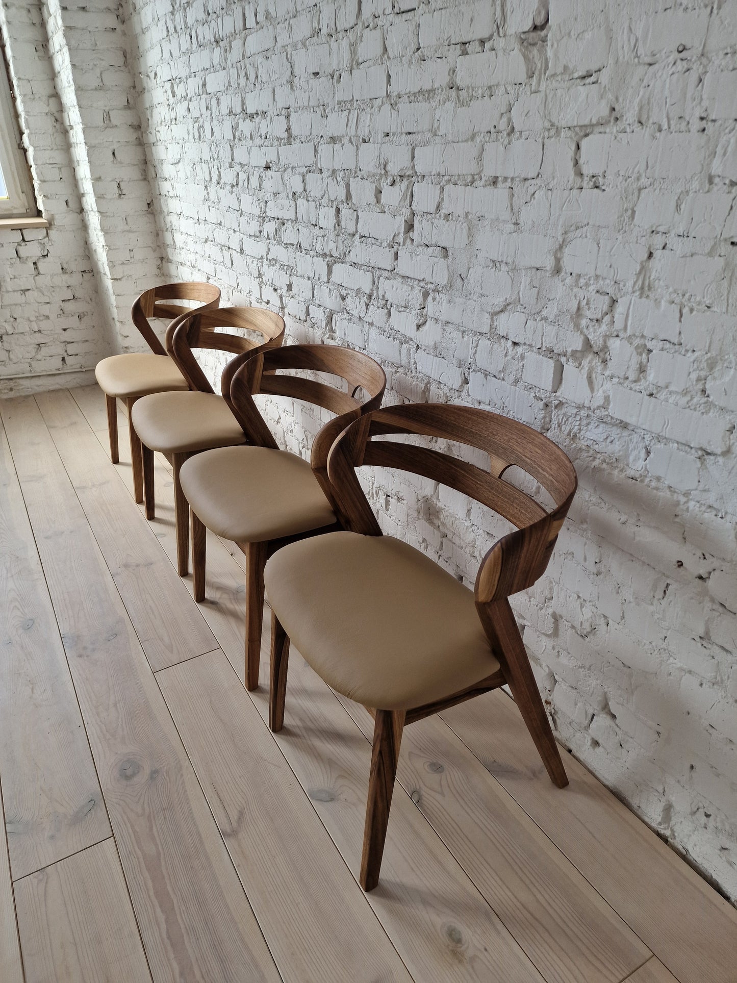 Solid walnut and natural leather curved dining chairs - style and high quality.