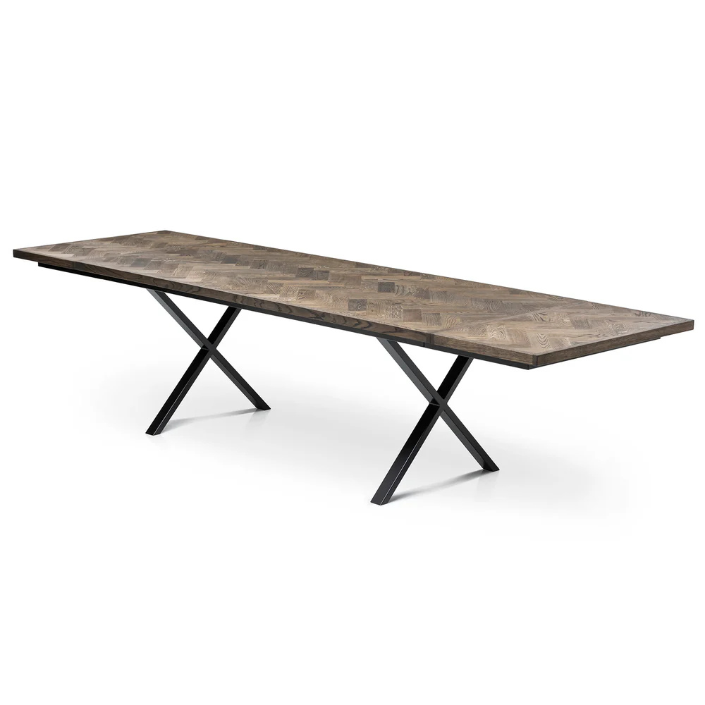 Gaia herringbone solid wood extendable dining table in charcoal oak with cross metal legs – luxury solid wood furniture piece.