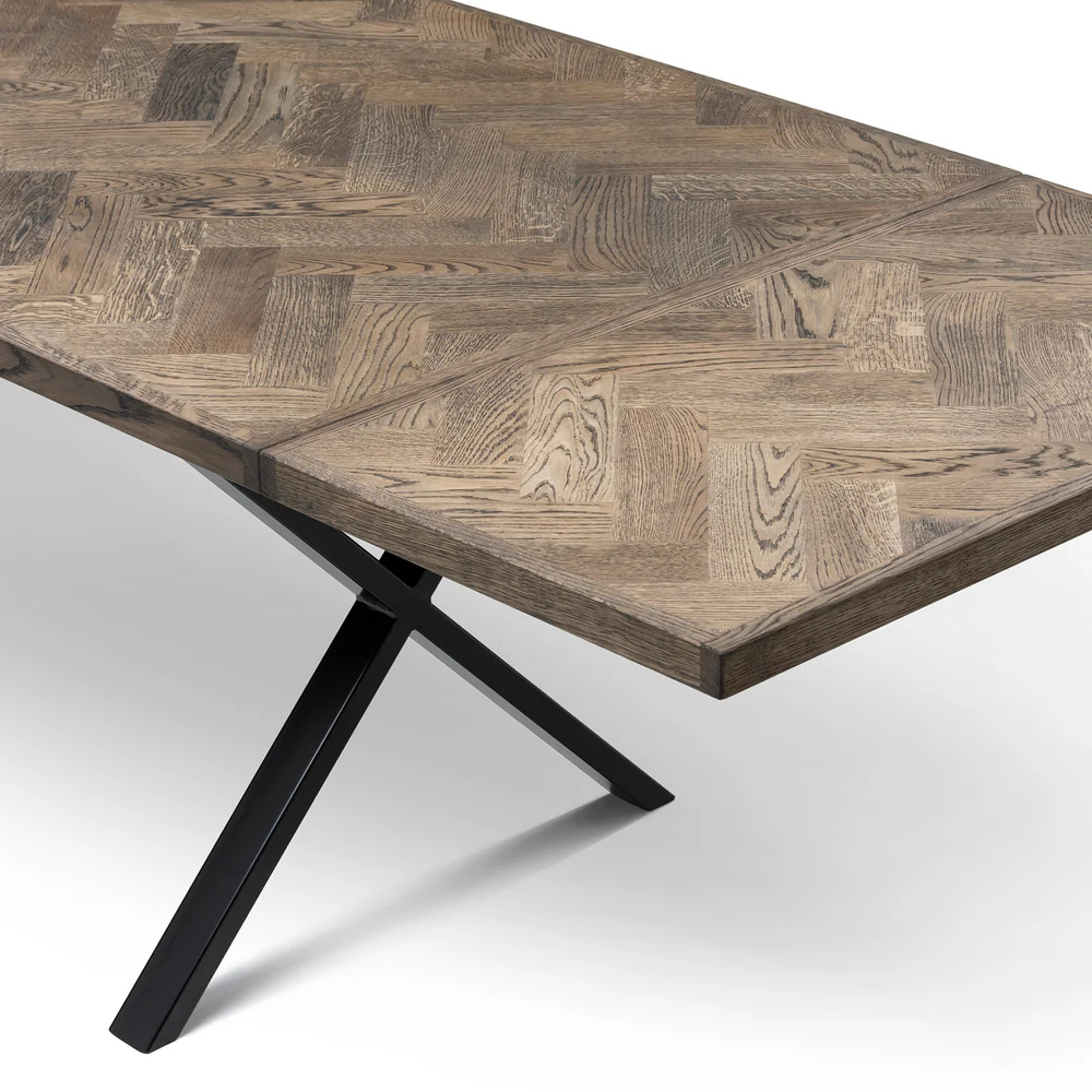 Gaia herringbone solid wood extendable dining table in charcoal oak with cross metal legs – luxury solid wood furniture piece.