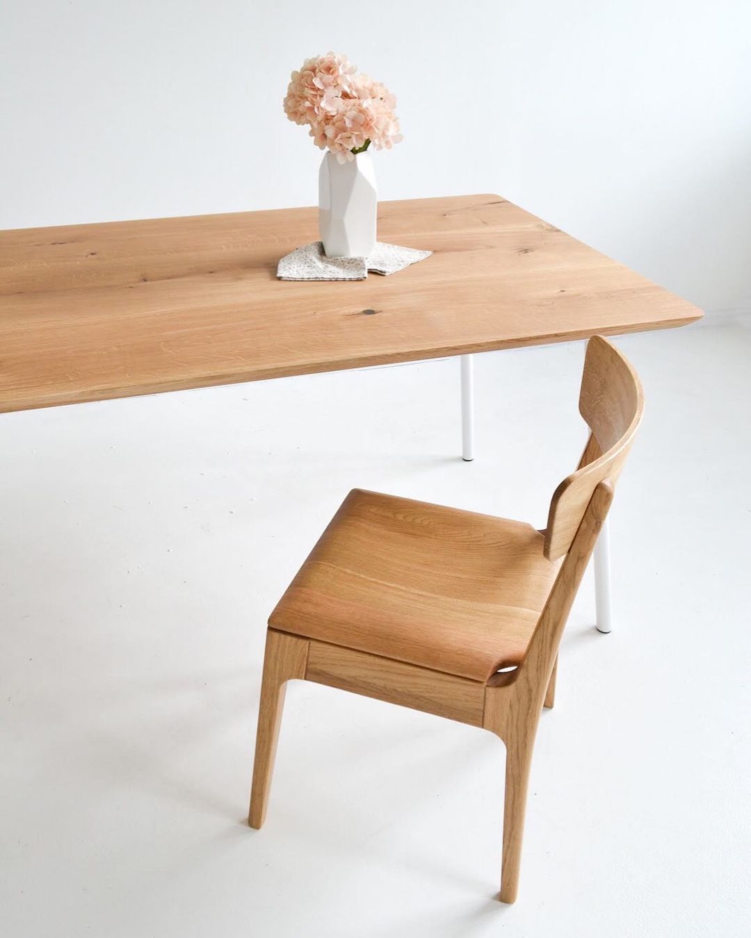 Minimalistic solid wood dining chair in natural oak with a wood seat.