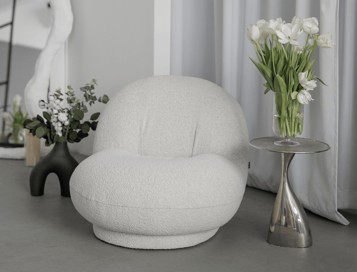 Cozy bouclé armchair with curved silhouette – a trendy addition to any space.