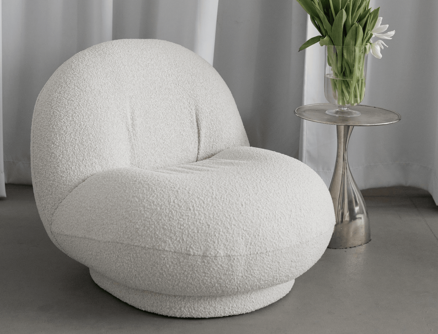 Cozy bouclé armchair with curved silhouette – a trendy addition to any space.