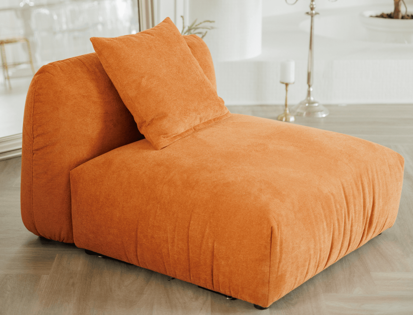Contemporary armchair without armrests in textured orange fabric – a bold, modern touch.