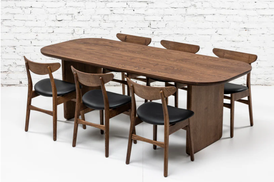 Handcrafted solid wood dining table with wooden plate legs in chocolate oak with matching dining chairs with black leather.