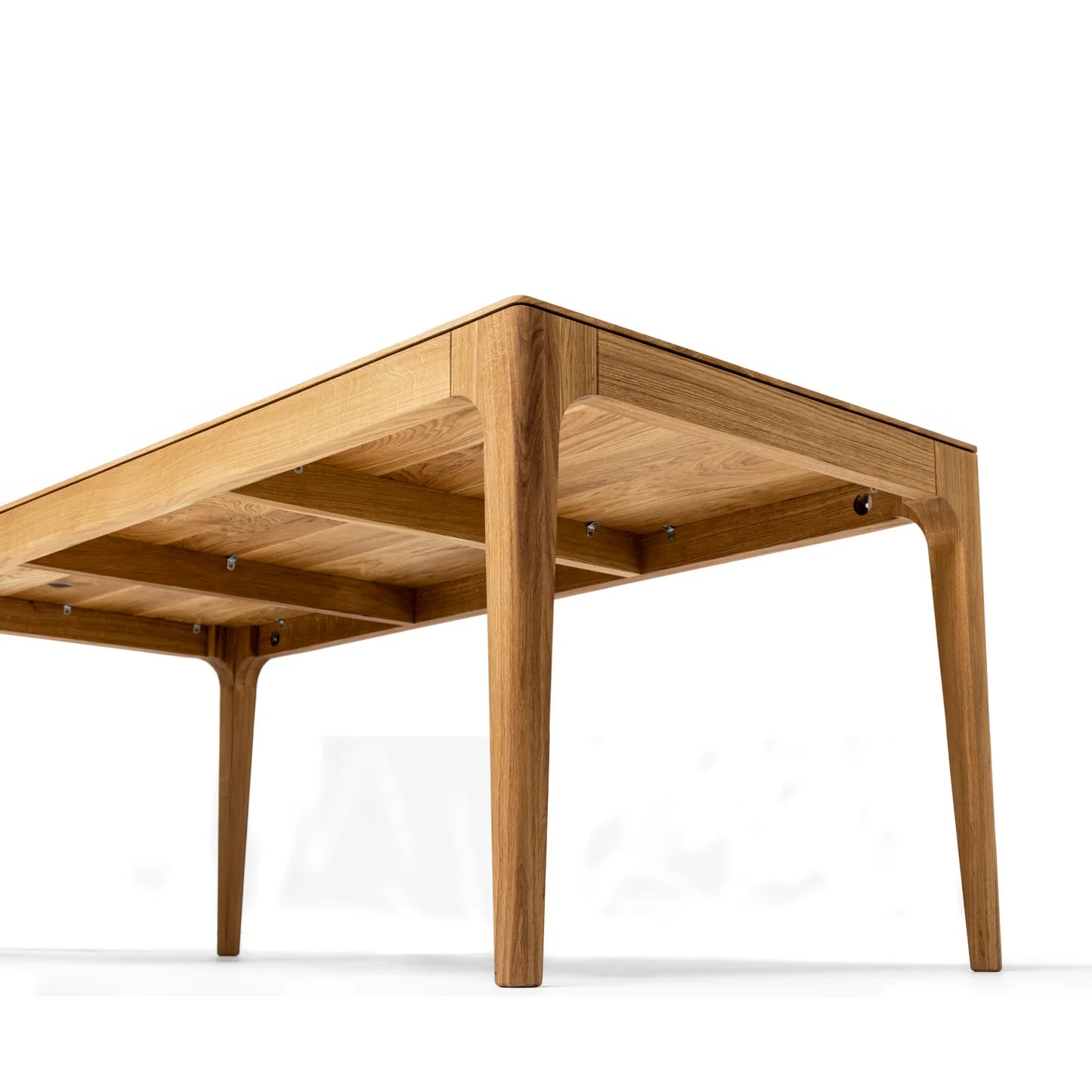Rectangular solid wood dining table with hidden extension mechanism in natural oak.