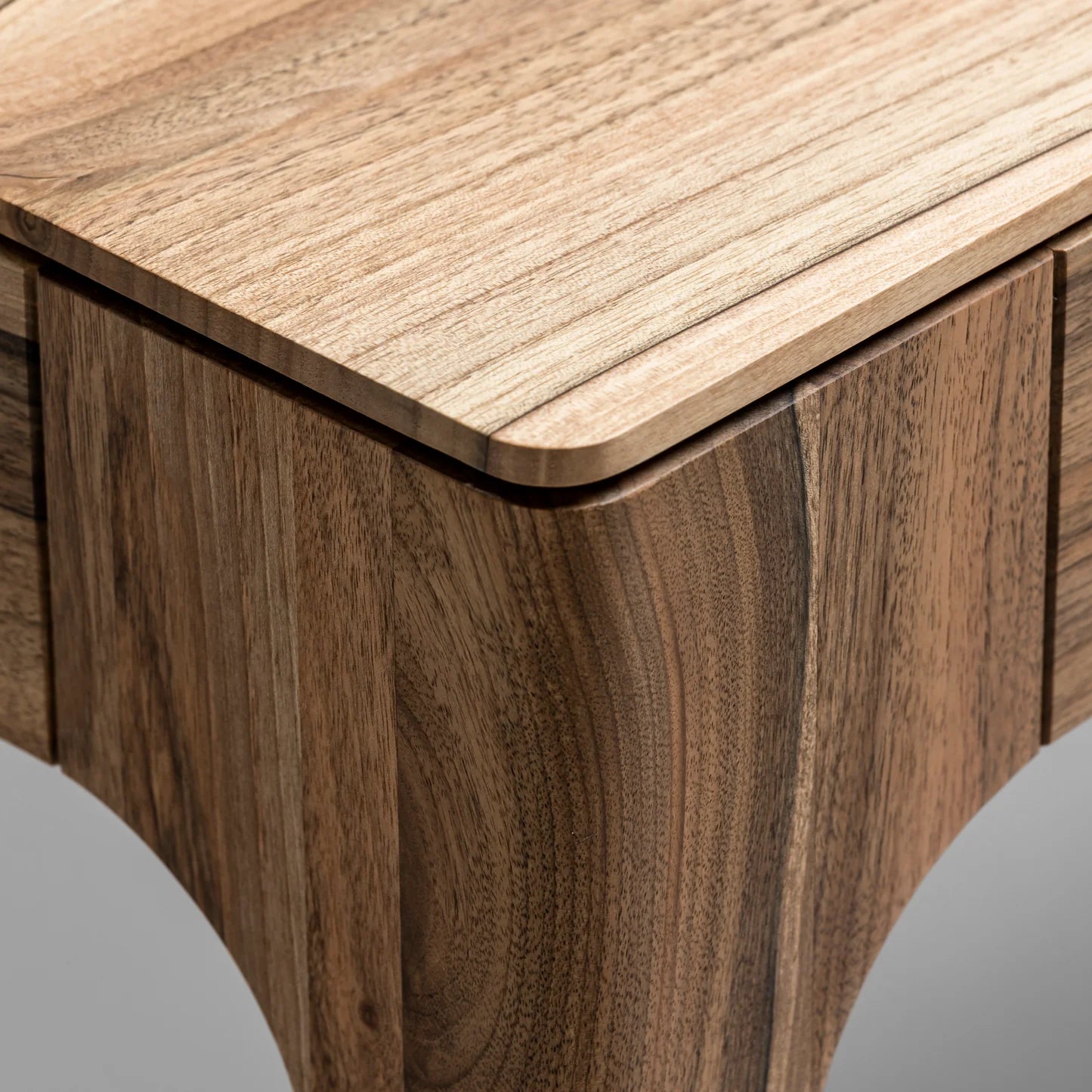 Rectangular solid wood dining table with hidden extension mechanism in natural walnut.