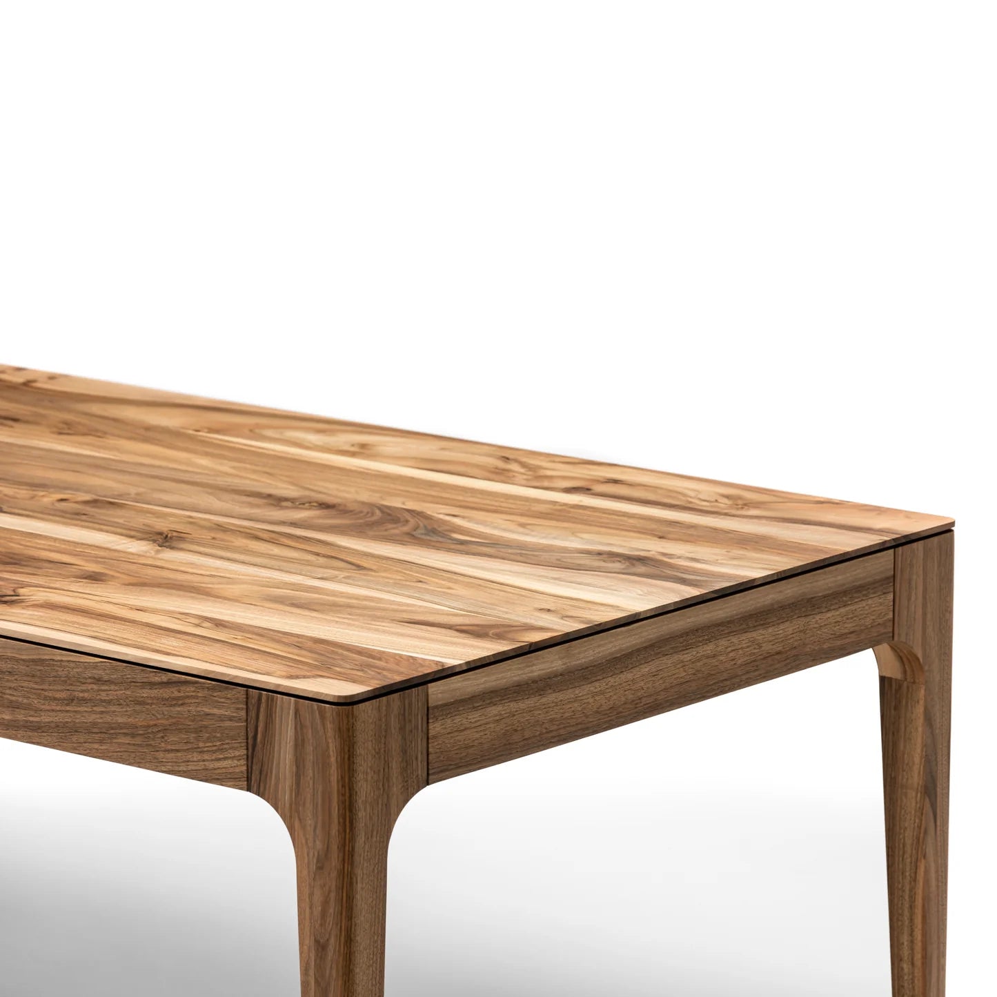 Rectangular solid wood dining table with hidden extension mechanism in natural walnut.