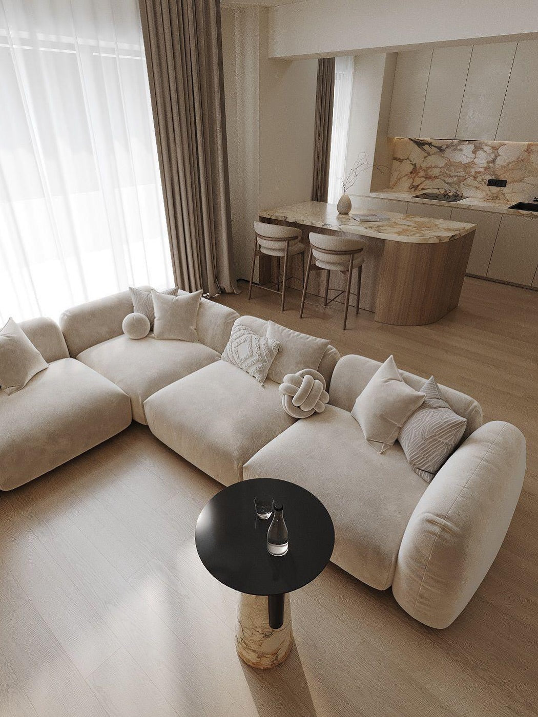 Beige modulsoffa i sammet med puffeffekt och dekorativa kuddar i ett elegant, modernt beige vardagsrum med stenkök och stenbord.