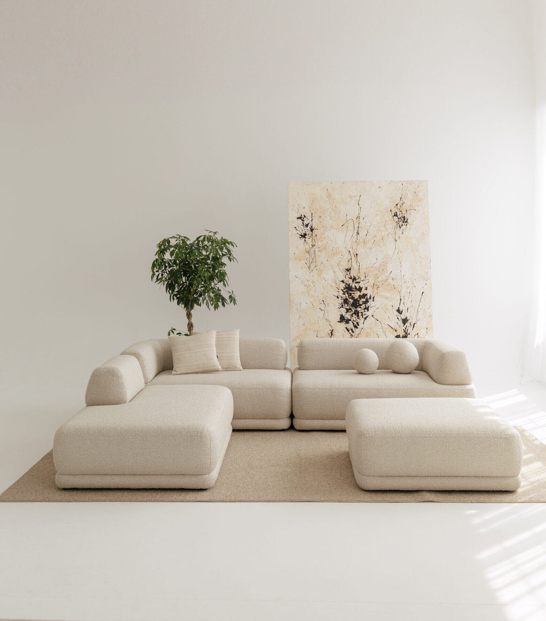 Designer modular sofa in beige fabric in studio with decorative pillows. 