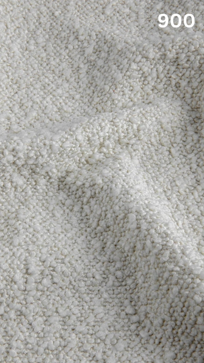 Close-up of textured white bouclé fabric for sofas with a pattern and number '900' in the corner.