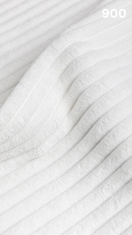 Close-up of white textured premium corduroy fabric for sofas with a number '900' in the corner. 