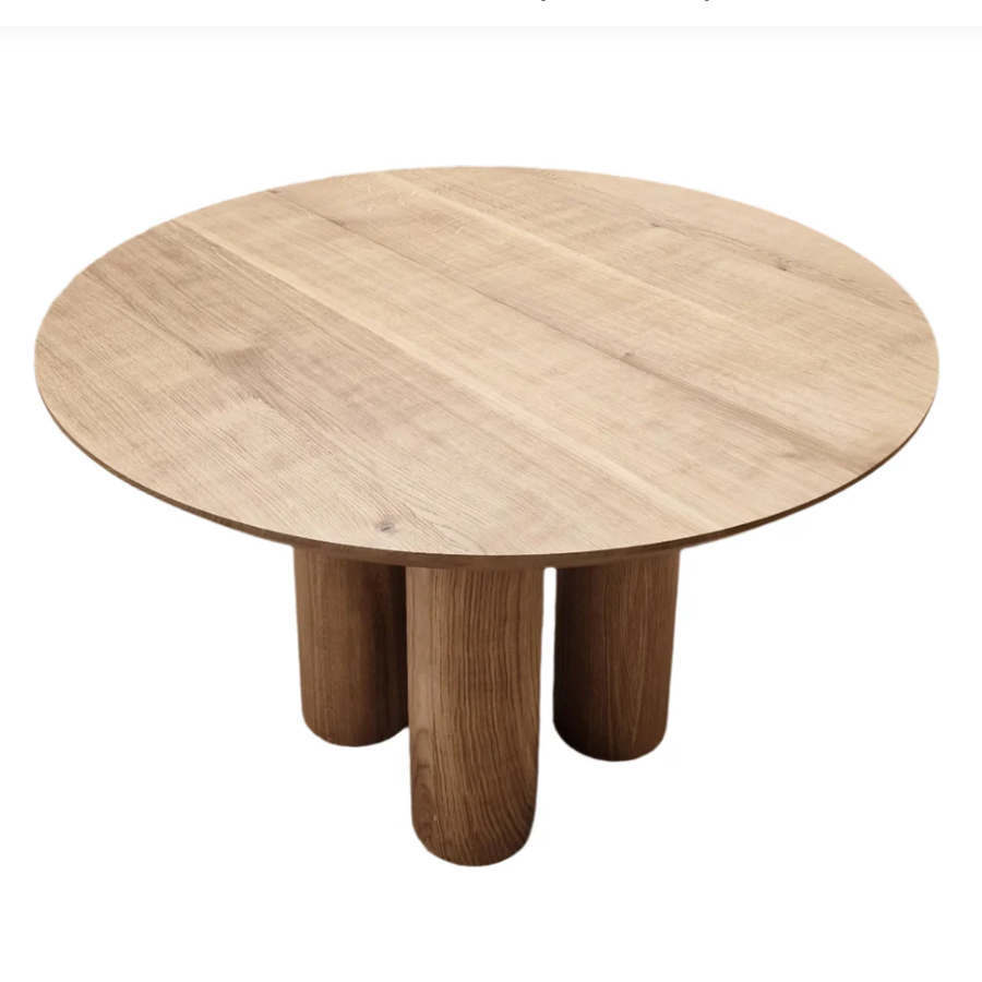 Handcrafted solid wood dining table with four round legs in natural oak. 