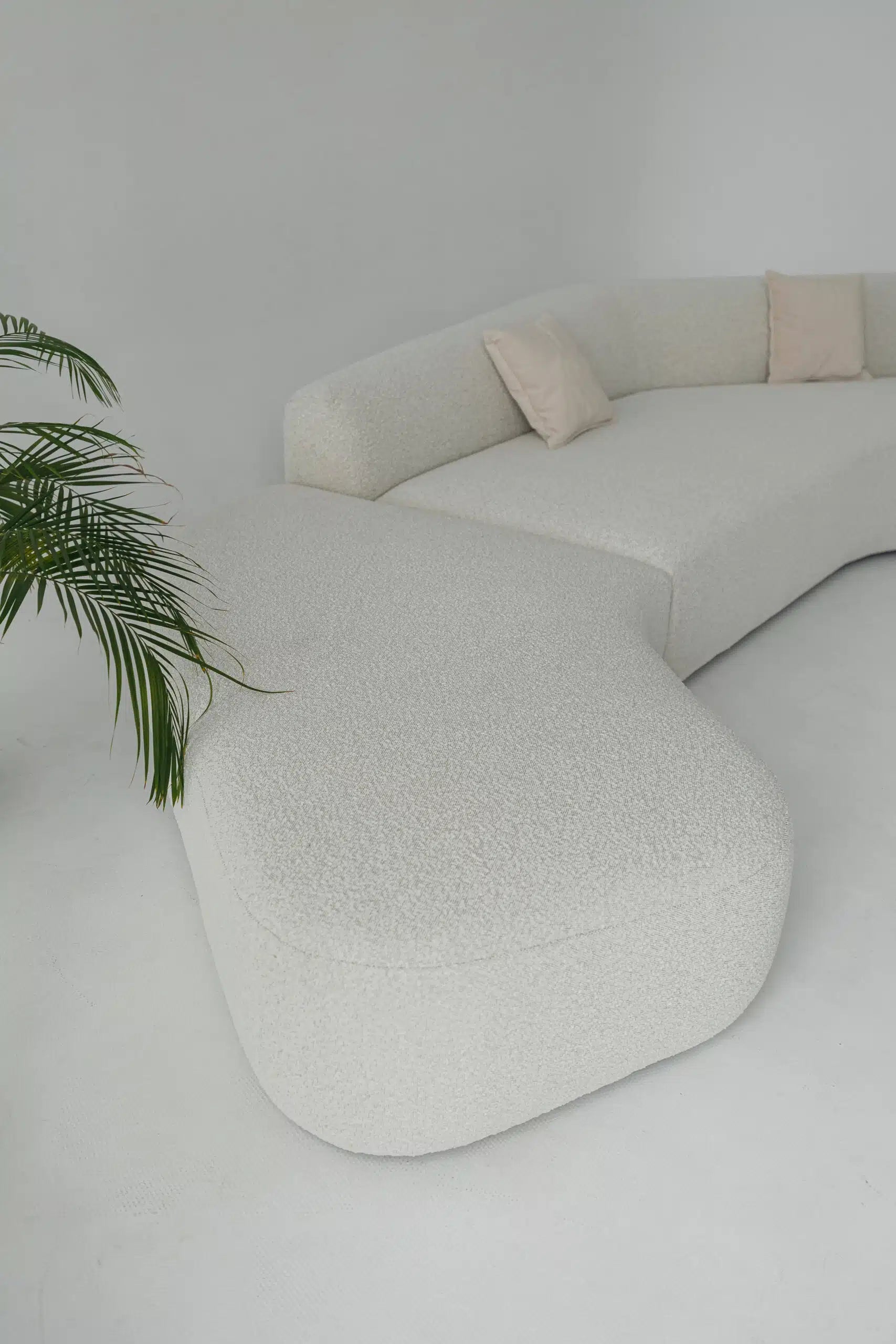 Modern white boucle sofa with textured design against a plain wall