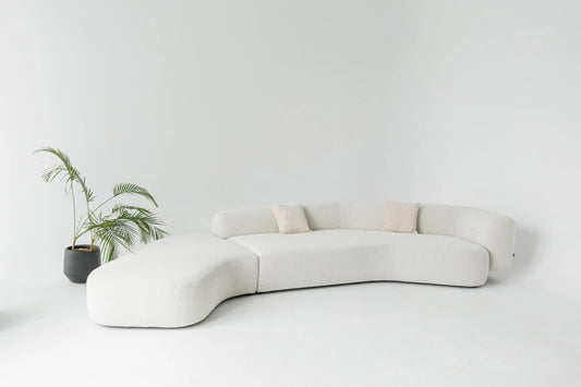 Modern white elegant sofa with a plant on a white background