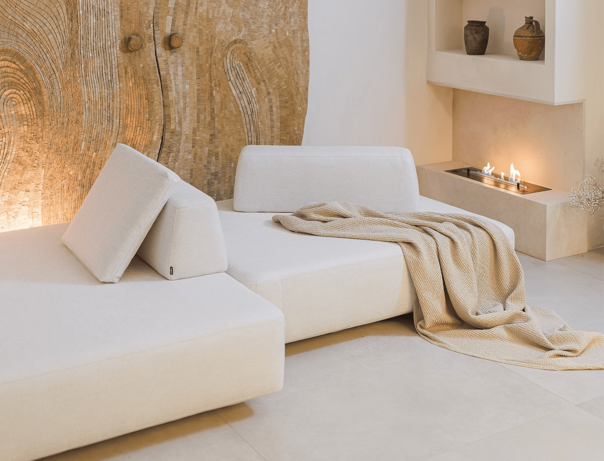 Modern living room with white modular sofa, wooden door, and decorative items.