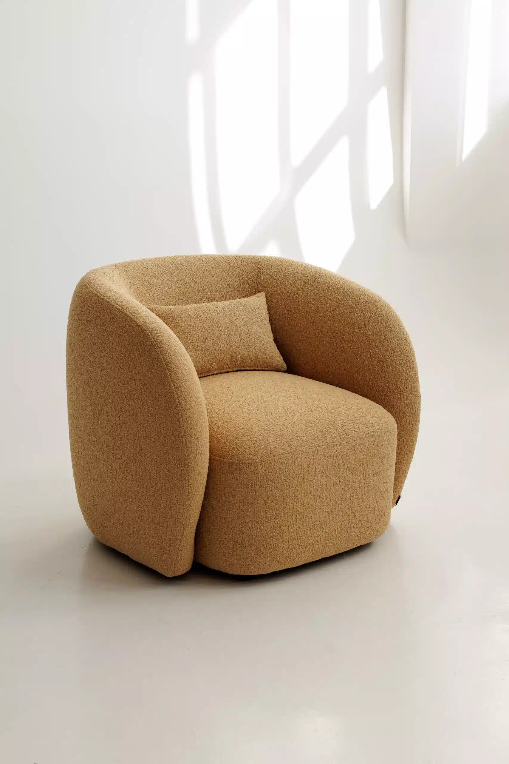 Yellow boucle armchair on a white floor with a white curtain background