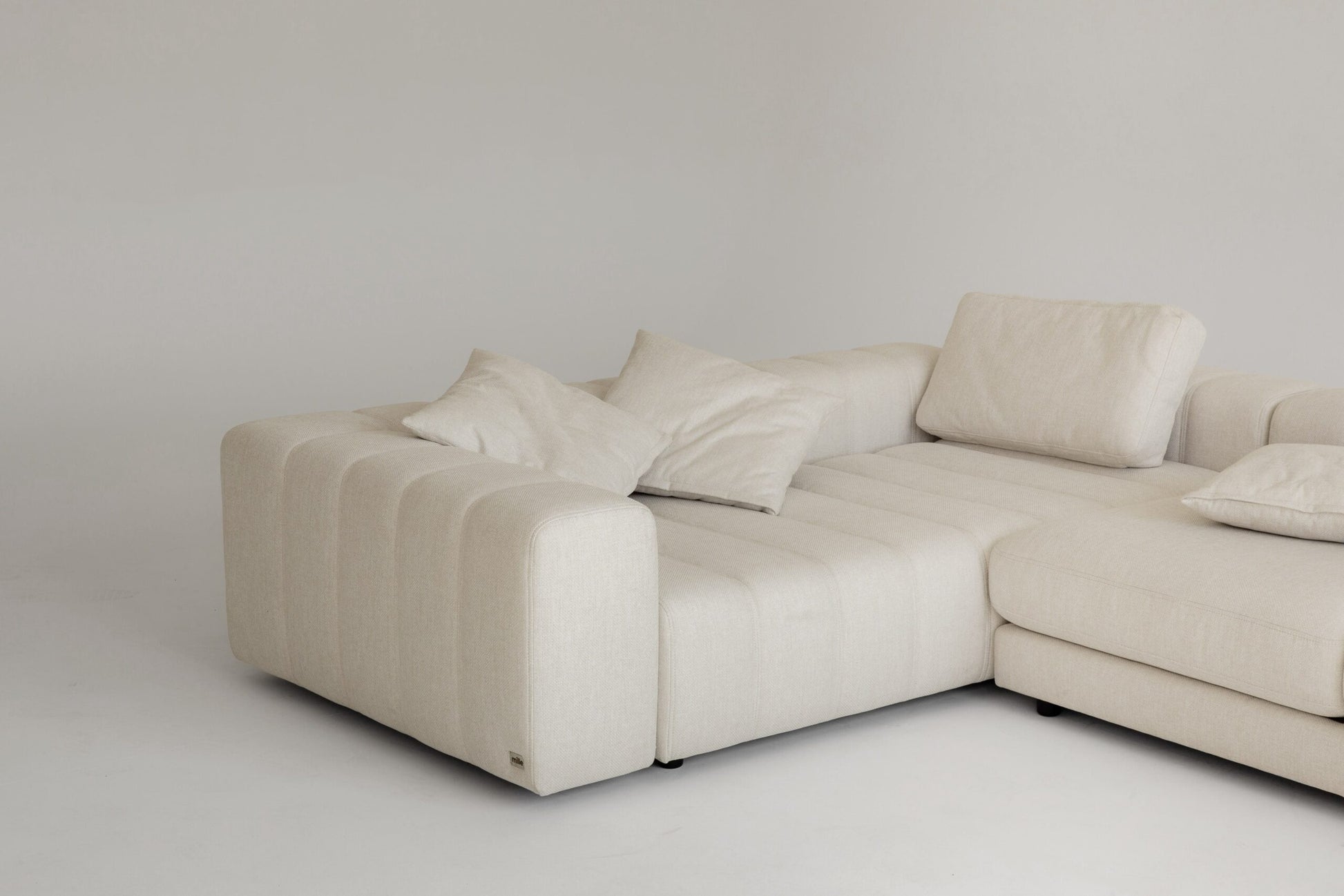 Luxury memory foam beige sectional sofa with cushions on a plain background