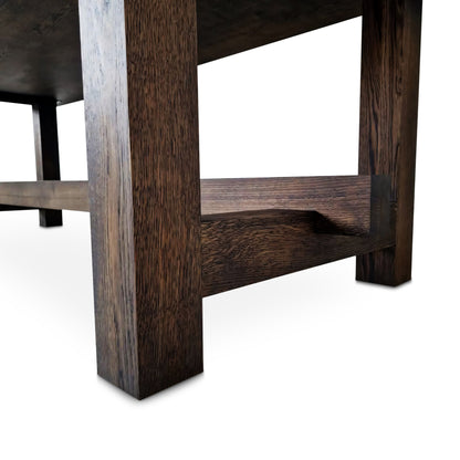 Detailed view of the Elsa rustic farmer-style dining table in rich chocolate oak, showcasing bespoke craftsmanship and FSC certified solid wood planks. This rectangular, extendable table by Talia Haus is a luxurious and sustainable piece, available in custom sizes and finishes including oak and walnut. A premium, handcrafted design perfect for elegant and timeless interiors.