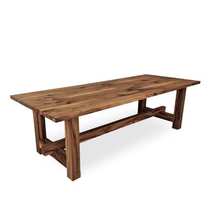 ELSA rustic farmer-style dining table made of solid walnut wood, rectangular and extendable, with open leg design, shown from a long corner view.
