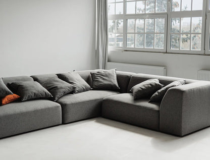 Gray sectional sofa in a room with large windows.