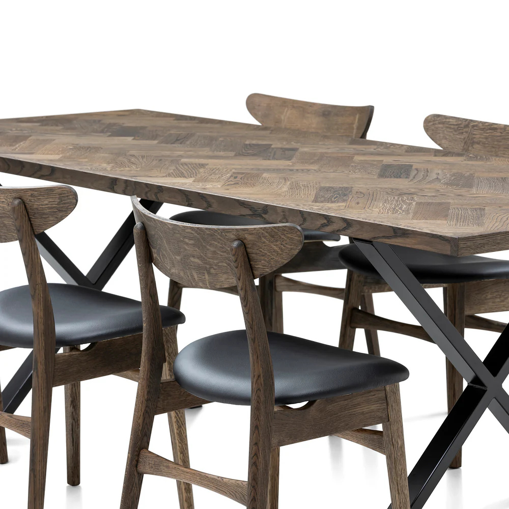 Gaia herringbone solid wood extendable dining table in charcoal oak with cross metal legs – luxury solid wood furniture piece.