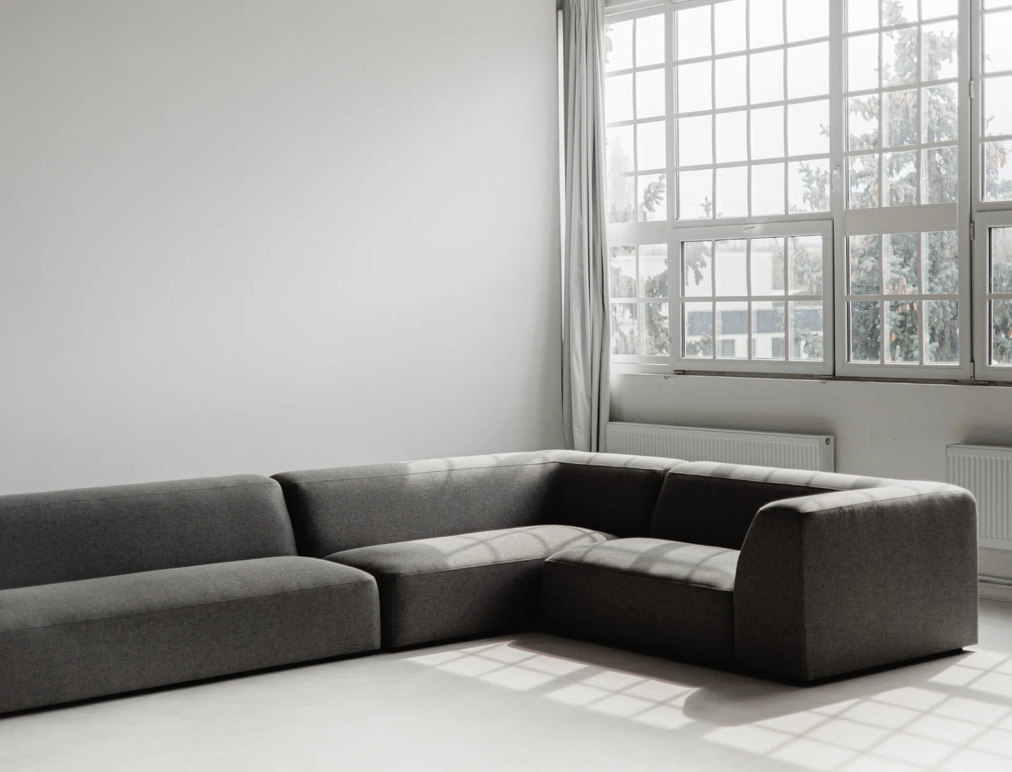 Gray sectional sofa in a room with large windows