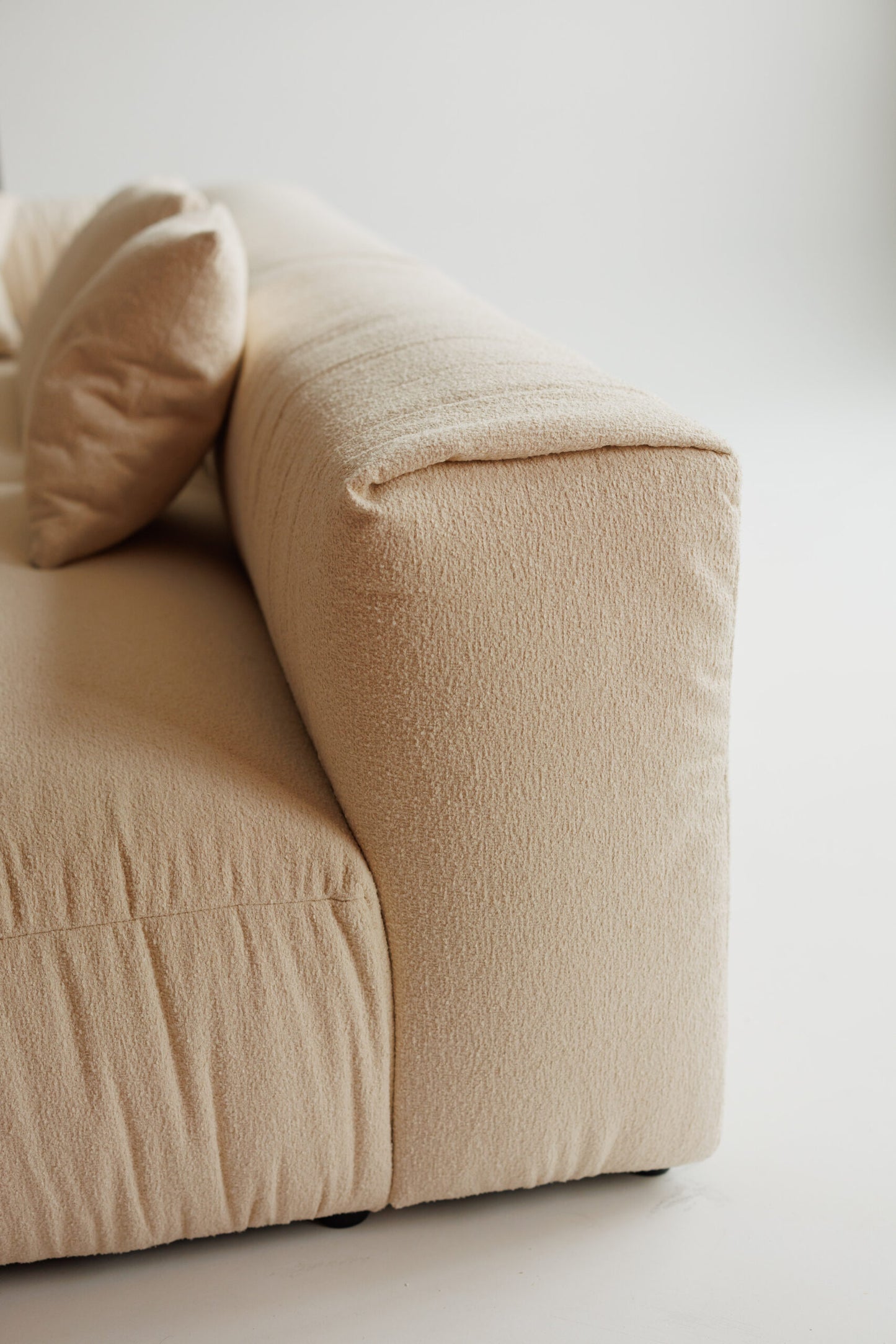 Beige sofa with a pillow on a light background