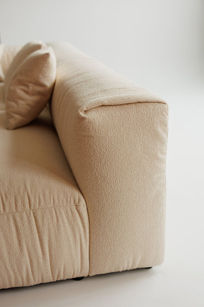 Beige sofa with a pillow on a light background