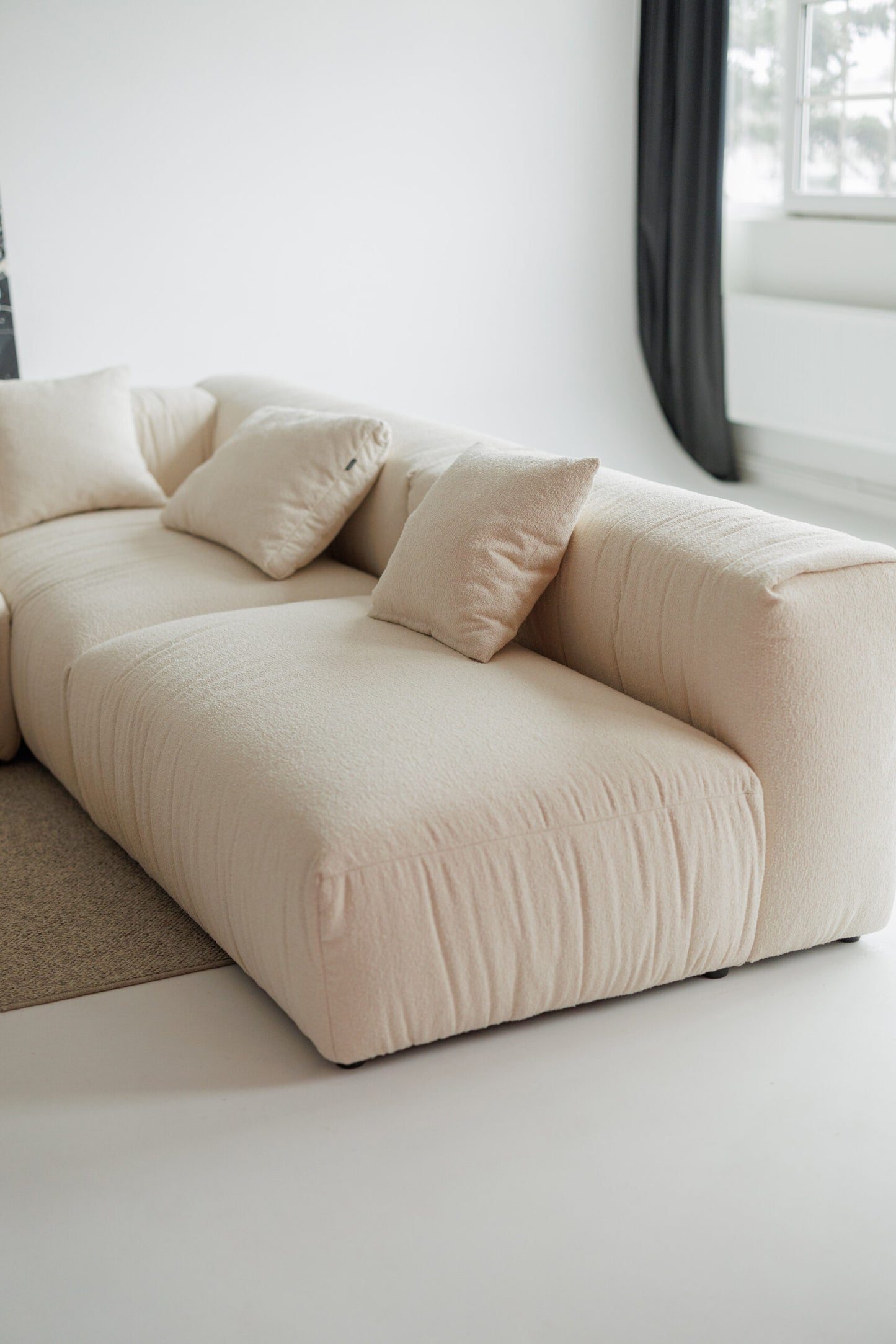 Beige sofa with cushions in a minimalistic room