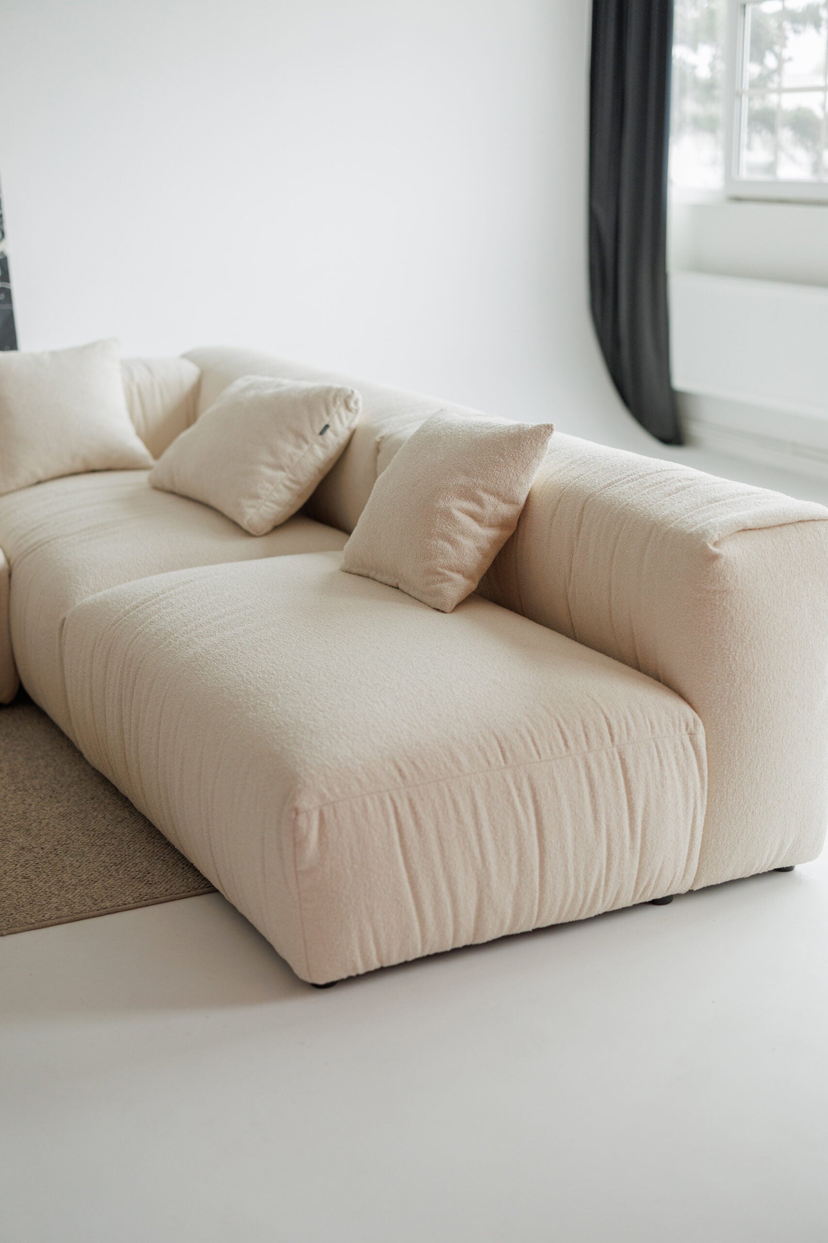 Beige sofa with cushions in a minimalistic room