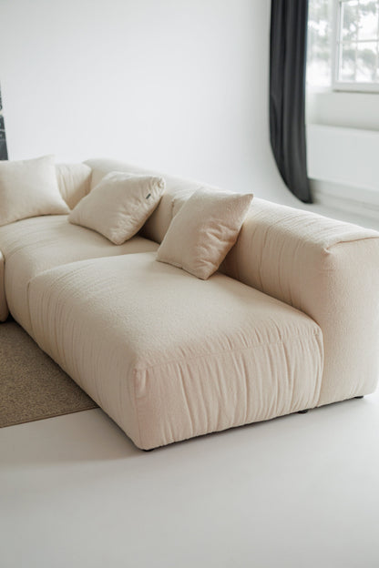 Beige sofa with cushions in a minimalistic room