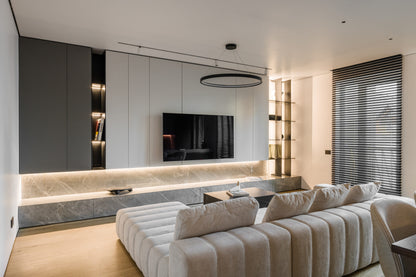 Modern living room with a beige luxury sofa, TV, and decorative elements.