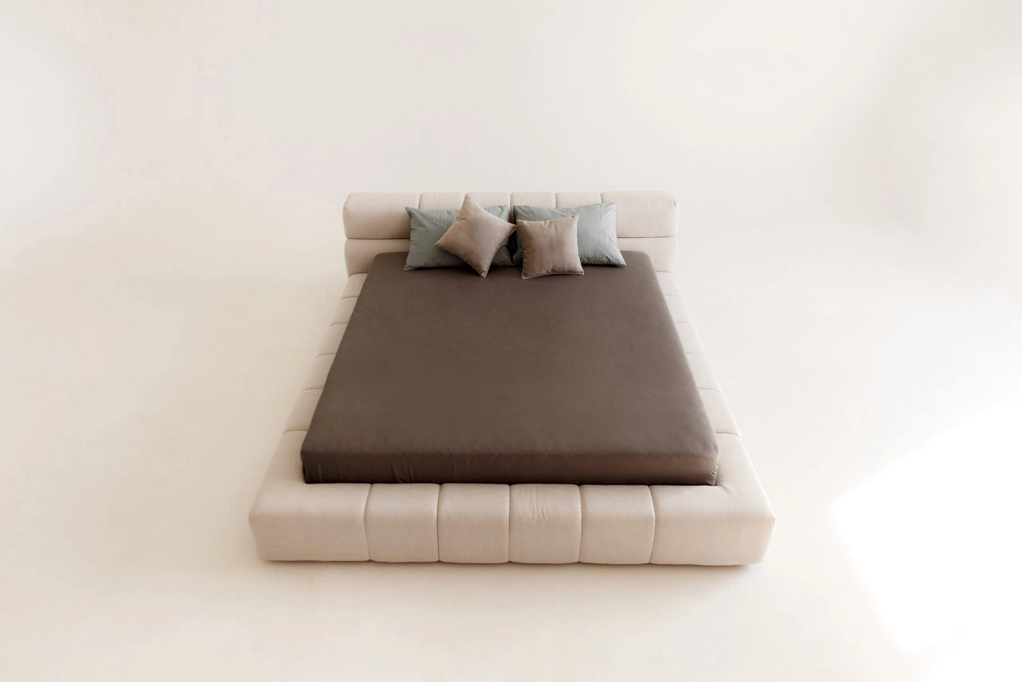 Modern upholstered bed with brown mattress and gray pillows on a white background