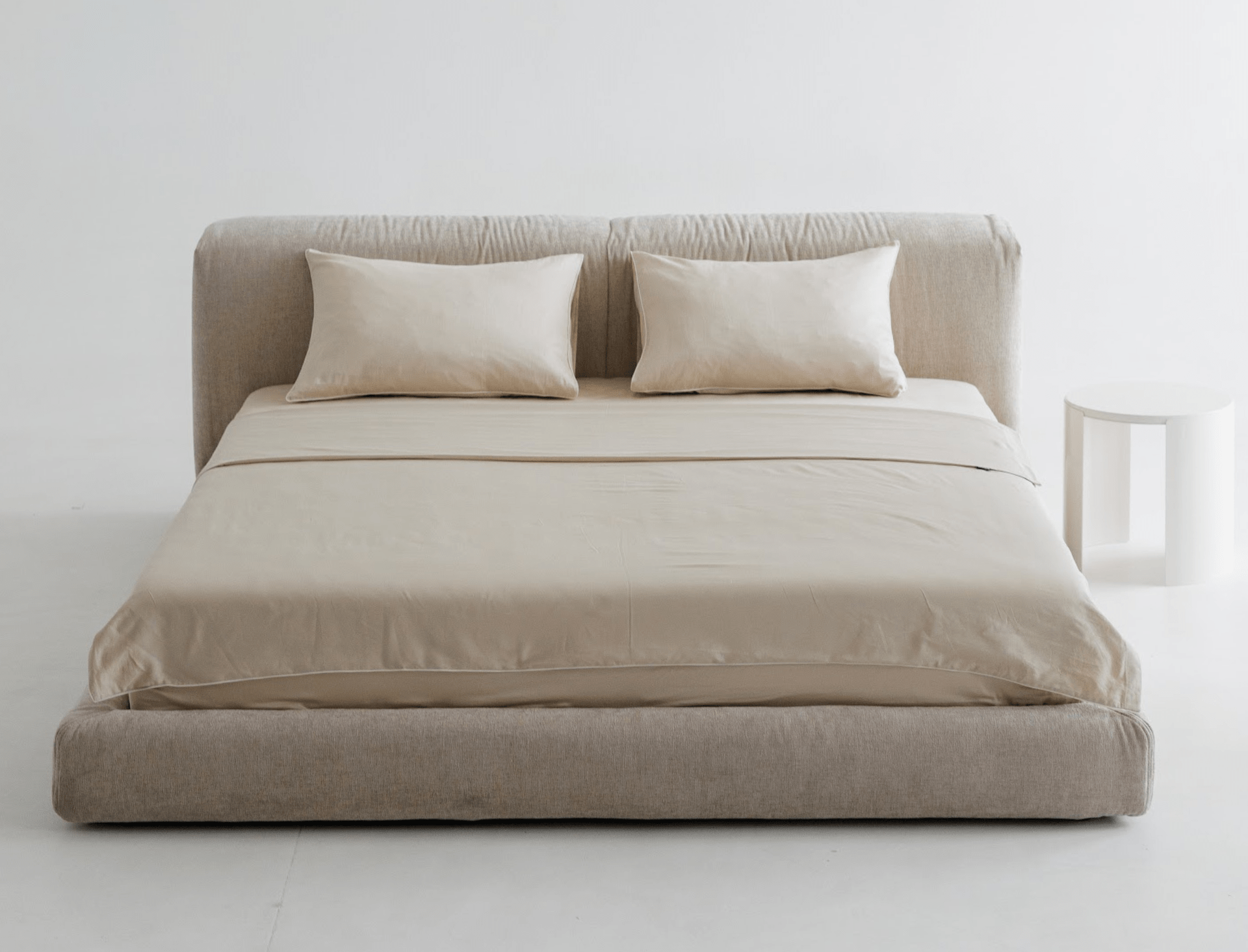 Premium quality bed with matching headboard and pillows against a white wall.
