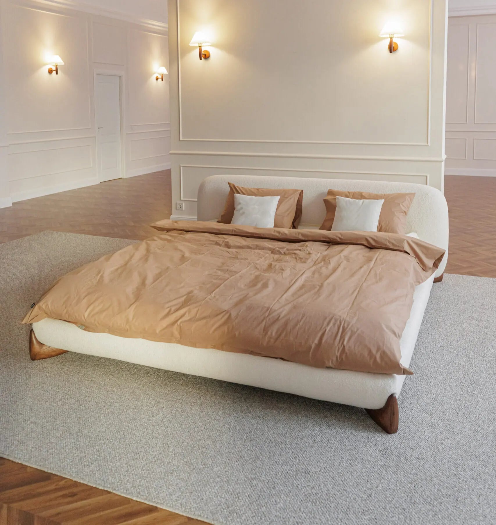 Stylish bedroom with a designer  bed covered in brown bedding and white pillows.