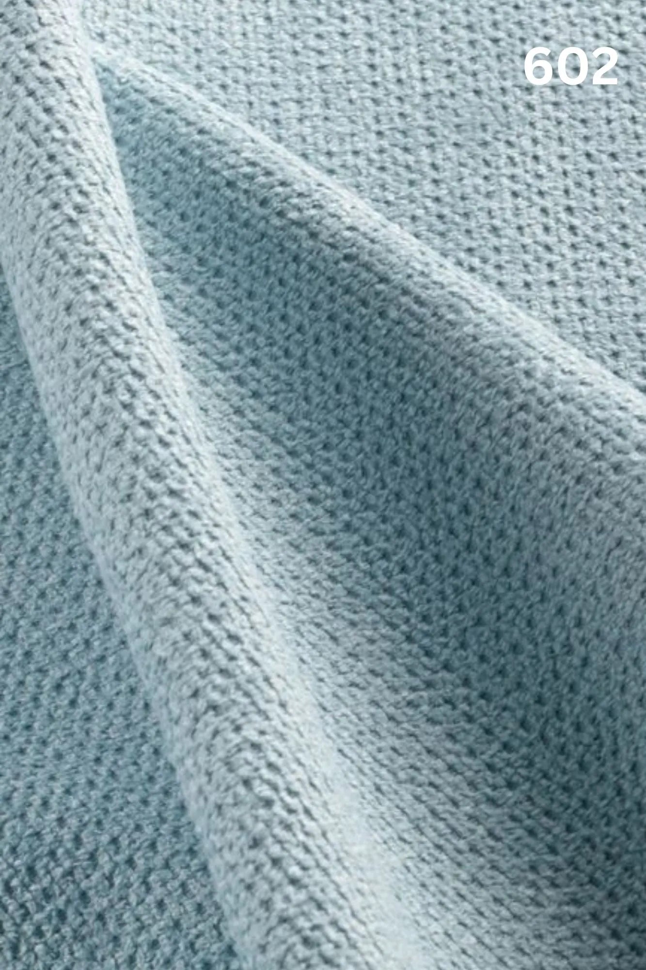 Close-up of light blue fabric texture with a slight wave pattern and number '602' in the corner. 