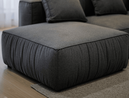 Black fabric ottoman sofa  on a wooden floor