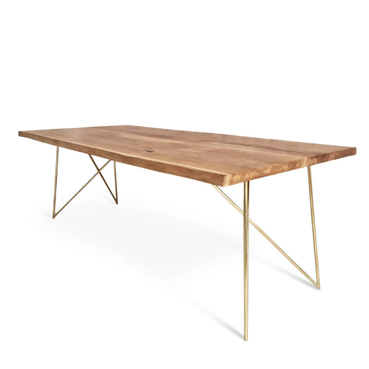 Close-up view of the Rhea solid wood dining table in oak or walnut with golden metal legs, featuring live or corner edge detailing.