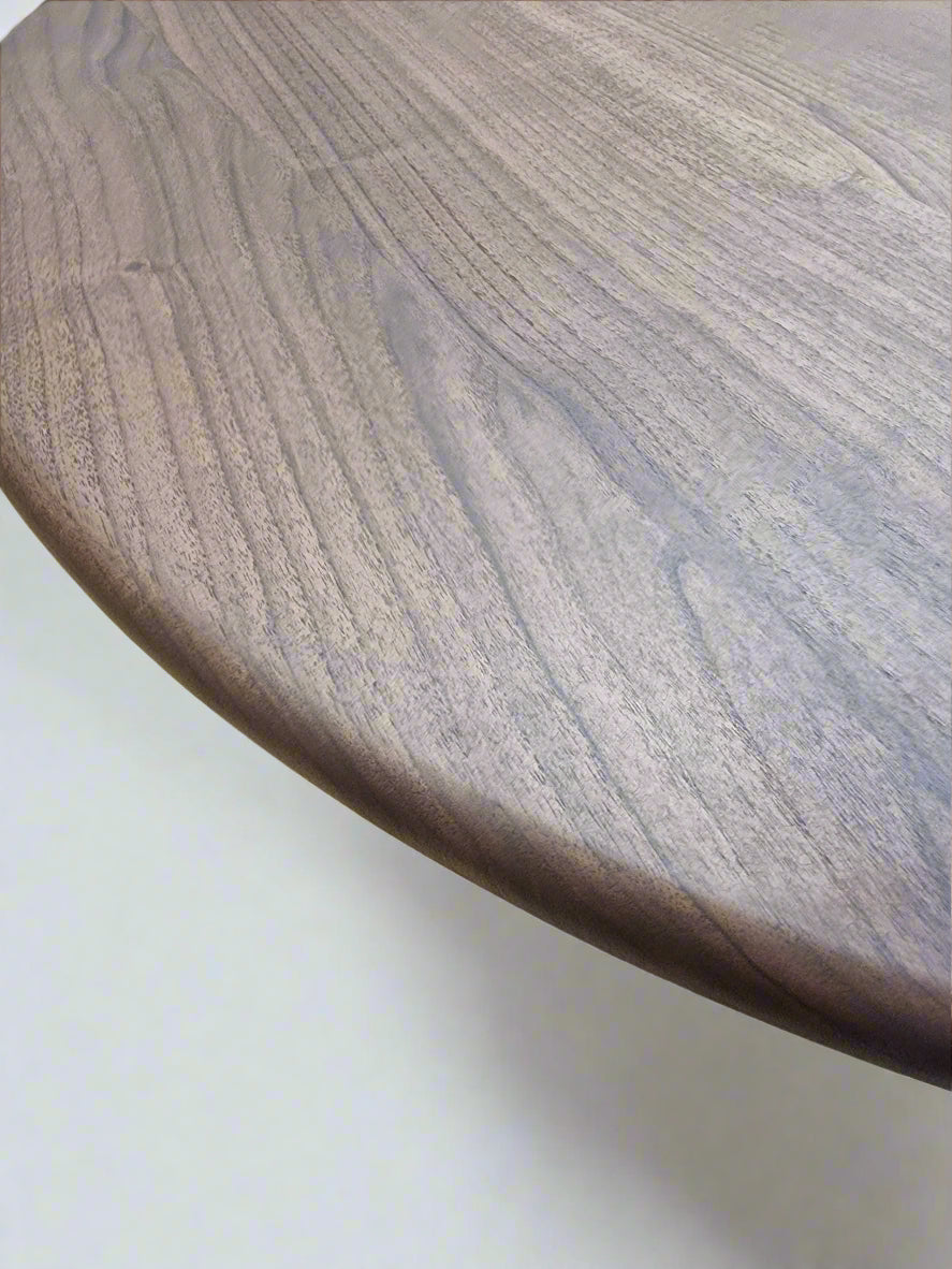 Ameline bespoke round dining table crafted from FSC certified solid walnut wood planks, featuring a minimalist designer style. This premium, sustainable piece by Talia Haus blends custom craftsmanship with luxury design, available in oak or walnut and extendable options for versatile dining spaces.