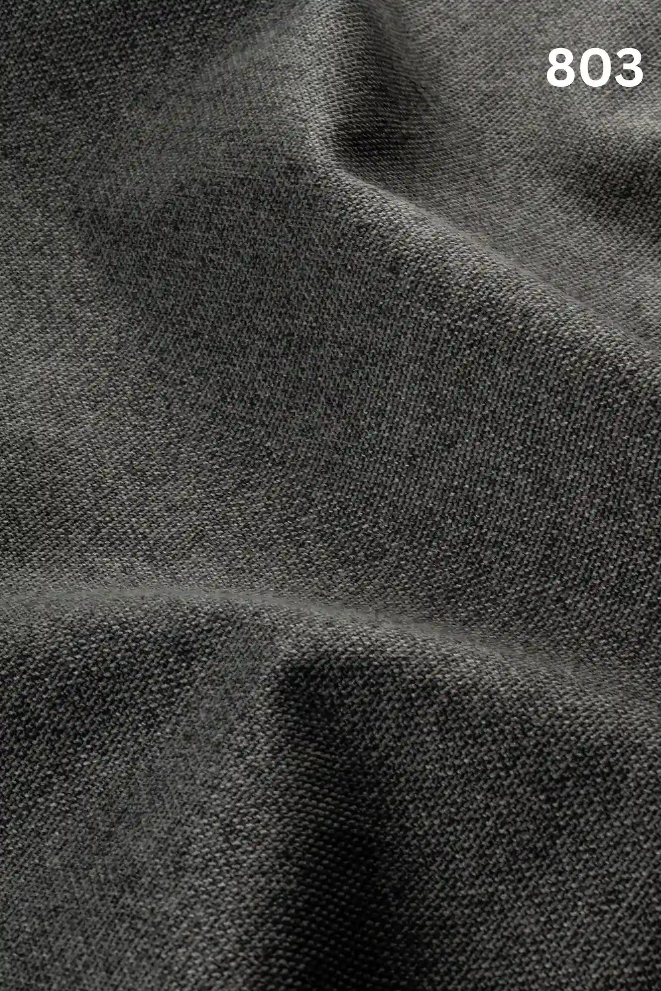 Close-up of black colored woven textured fabric for sofas with number '803' in the corner. 