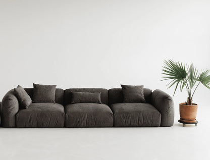 Gray velvet modular sofa with cushions on a white background