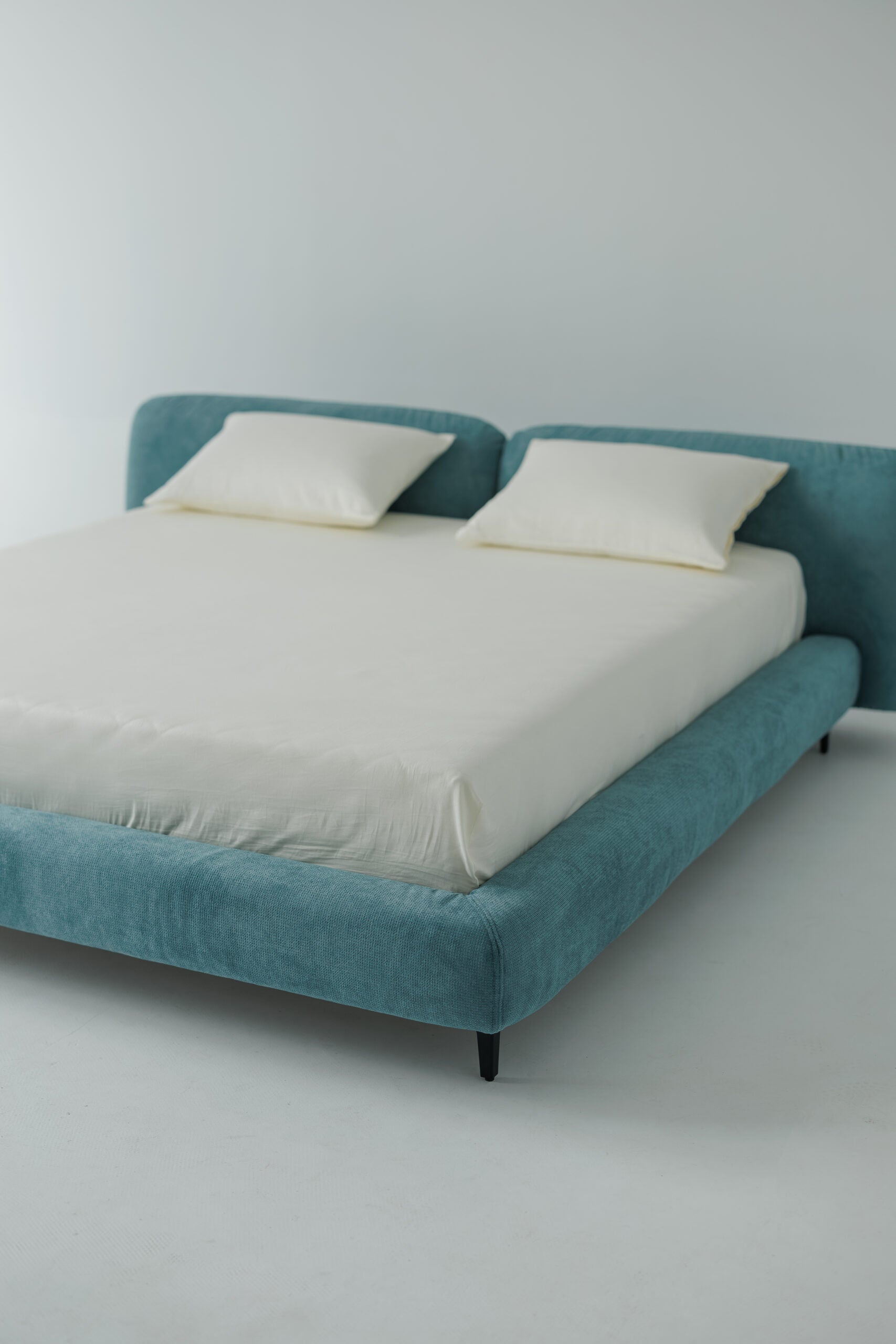 TESA bed upholstered in premium blue fabric, custom bespoke designer luxury, showcased in a photoshoot by Talia Haus.
