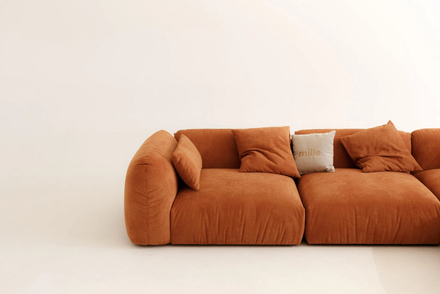 Orange modular sofa with cushions on a white background