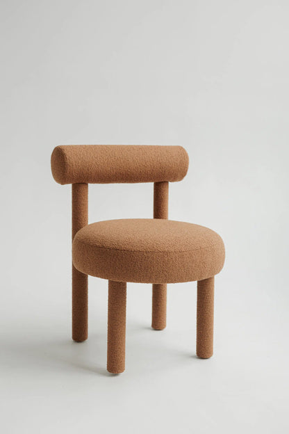 Brown upholstered bouclé chair with a minimalist design on a light gray background