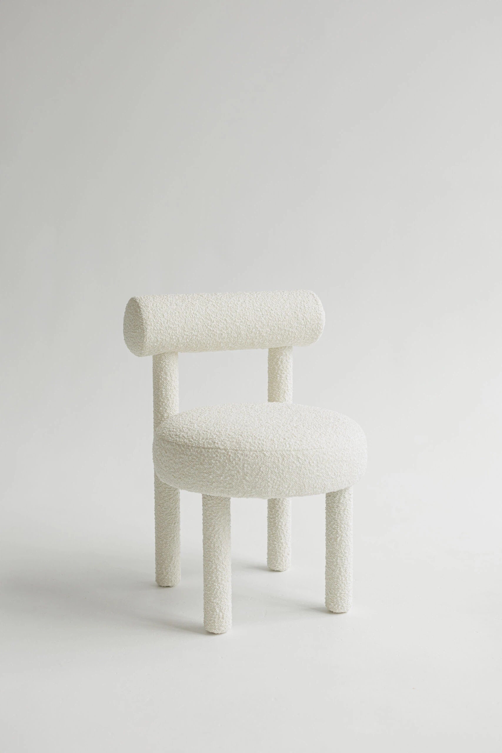 White upholstered boucle chair on a light gray background