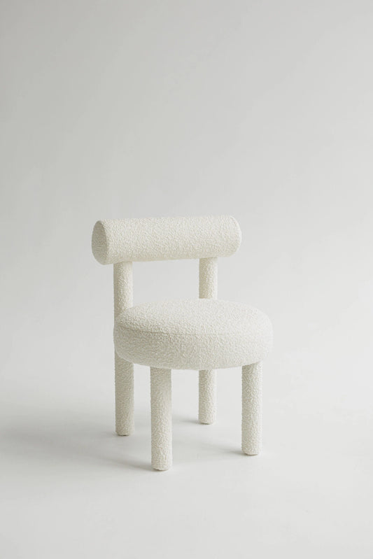White upholstered boucle chair on a light gray background