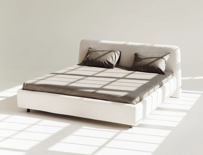 White bed with gray bedding in a minimalistic room