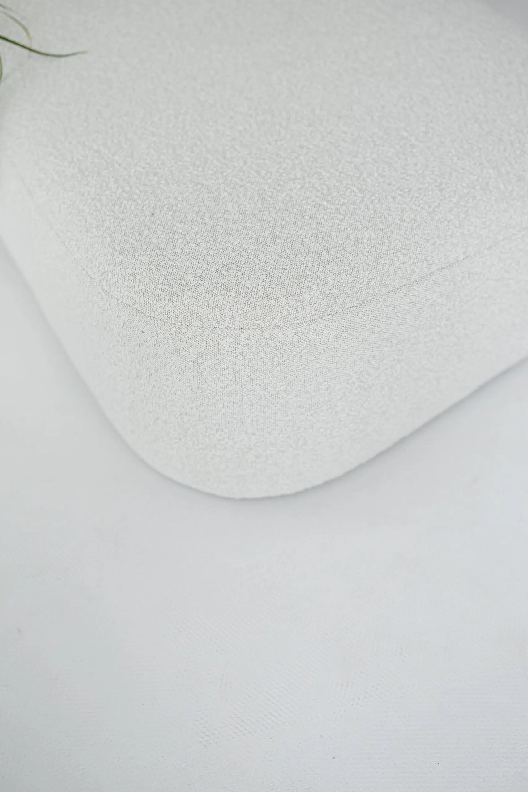 White textured boucle sofa corner on a light gray background
